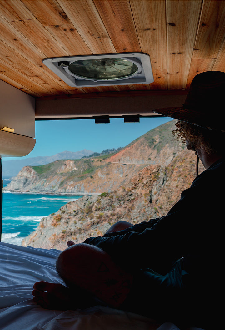 Man overlooking ocean in a Roadhouse camper van